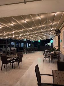 a restaurant with tables and chairs and lights on the ceiling at Guesthouse Pri Tonetu in Ptuj