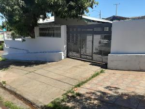 a fence and a gate in front of a house at Hospedaje al inicio de la Costanera in Encarnación