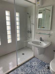 a white bathroom with a shower and a sink at Bell Cottage B&B in Yongan