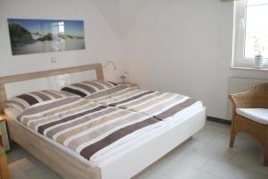 a large bed in a room with a chair at Strandstraße 21 Whg 5 in Zingst