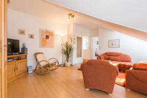a living room with a couch and chairs and a tv at Likedeeler Weg 1 Whg 24 in Zingst