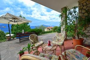 a patio with chairs and a table and an umbrella at Bed and Breakfast Due Leoni in Torri del Benaco