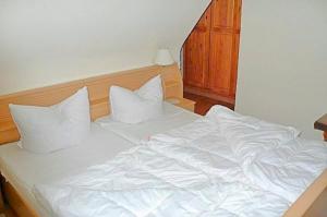 a white bed with two pillows on top of it at Hennig, Otti in Zingst
