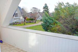 - un balcon blanc avec vue sur une maison dans l'établissement Hennig, Otti, à Zingst