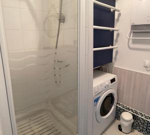 uma casa de banho com um chuveiro e uma máquina de lavar roupa em L'Aéroplage, Appartement Standing Rénové Vacances 40mètres plage em Berck-sur-Mer