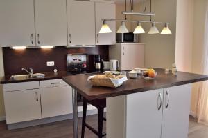a kitchen with white cabinets and a wooden counter top at Fehmarnstrand 78 App 14 in Staberdorf