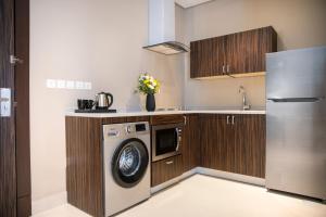 a kitchen with a washing machine and a refrigerator at Swiss Blue Hotel Hera in Jeddah