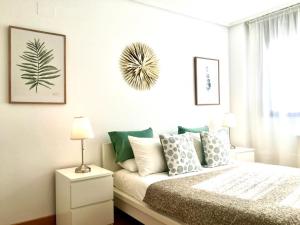 una camera da letto con un letto con cuscini verdi e bianchi di Apto1 Céntrico Frentebahía Garaje Incluido a Castro-Urdiales