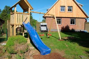 a playground with a slide in a yard at die kleine Villa in Rieseby