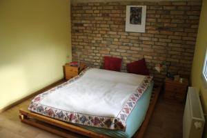 a bed in a room with a brick wall at Ferienhaus "Am Lindenhof" in Allerstorf