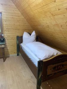 uma cama num quarto com tecto em madeira em Luxuriöses Ferienhaus em Luftkurort Lückendorf