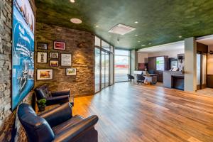 a lobby with leather chairs and a brick wall at ibis Styles Hamburg Barmbek in Hamburg