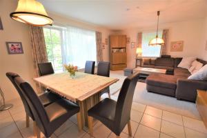 a living room with a table and chairs and a couch at Haus Antje-Kellenhusen Whg1 in Kellenhusen