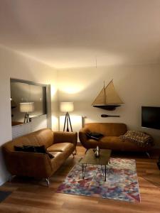 ハイリゲンハーフェンにあるOstsee - Maisonette - Appartement Nr 24 "24-Four-Seasons" im Strand Resortのリビングルーム(ブラウンソファ2台、ラグ付)
