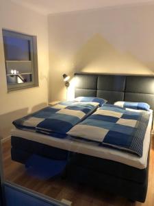 ハイリゲンハーフェンにあるOstsee - Maisonette - Appartement Nr 24 "24-Four-Seasons" im Strand Resortのベッドルーム1室(青と白の毛布付きのベッド1台付)