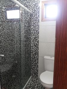 a bathroom with a toilet and a glass shower at Chalé 2 pinheiros in Urubici