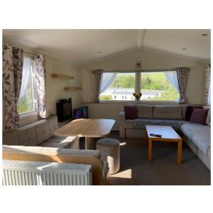 Hollington的住宿－Cosy 3-Bed Caravan combe haven st Leonards on sea，客厅配有沙发和桌子