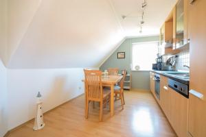 a kitchen and dining room with a table and chairs at Hoppenberg 5a in Zingst