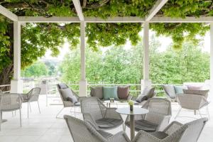 um pátio exterior com cadeiras, mesas e árvores em Casa das Lérias em Amarante