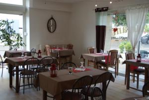 a restaurant with tables and chairs and a clock on the wall at Hotel de Got in Villandraut