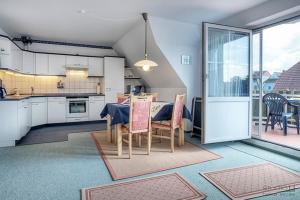 a kitchen and dining room with a table and chairs at Ostseewelle Whg 7 in Zingst