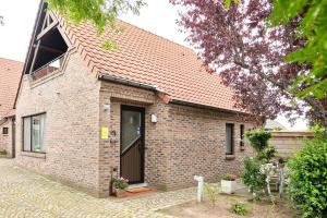 ein Backsteinhaus mit brauner Tür auf einer Straße in der Unterkunft Pieters Huis in Kinrooi