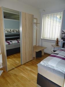 1 dormitorio con cama y espejo grande en 5-Sterne-Fewo "Facette", en Allenbach