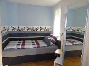 Dormitorio pequeño con cama y espejo en 5-Sterne-Fewo "Facette", en Allenbach
