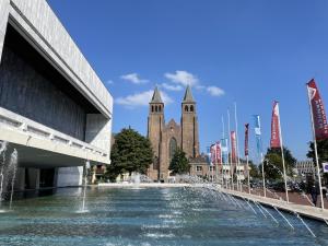 a fountain in front of a building with a church at Walburgis Residenties in Arnhem