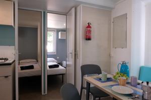 ein kleines Zimmer mit einem Tisch und einem Bett in der Unterkunft Happy Camp Mobile Homes in Camping Laguna Village in Caorle