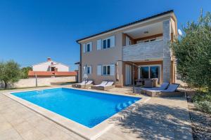 a villa with a swimming pool in front of a house at Villa Terlevic in Selina