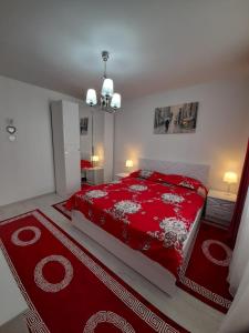 a bedroom with a red bed and a red rug at 2 rooms apartment Telecabinei Busteni in Buşteni