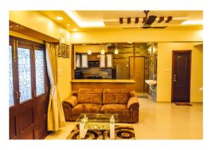 a living room with a couch and a glass table at 3BHK ALLADIN VILLA (COMMON POOL) in Mahabaleshwar