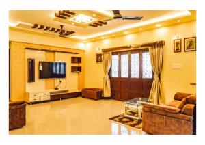 - un salon avec un canapé et une télévision dans l'établissement 3BHK ALLADIN VILLA (COMMON POOL), à Mahabaleshwar