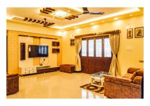 a living room with a couch and a tv at 3BHK ALLADIN VILLA (COMMON POOL) in Mahabaleshwar