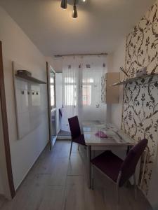 a kitchen and dining room with a table and chairs at 2 rooms apartment Telecabinei Busteni in Buşteni