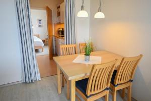 a dining room table and chairs in a room with a bedroom at Zur schönen Aussicht - FW 6 in Dahme