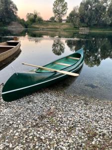 una canoa verde seduta sulla riva di un lago di Holiday Home Navis a Karlovac