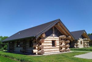 uma cabana de madeira com uma pilha de troncos em Naturstammhaus Tollensesee em Krickow