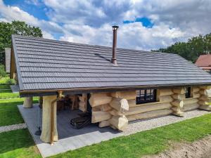 eine Blockhütte mit einem Zinndach oben in der Unterkunft Naturstammhaus Tollensesee in Krickow