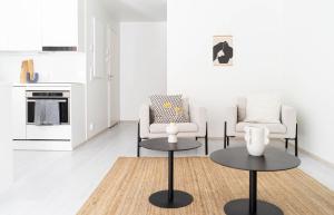 a living room with two chairs and two tables at NEW stylish 2br apartment in the city center in Oulu