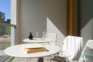 NEW stylish 2br apartment in the city center في أولو: طاولتين وكراسي على شرفة مع كؤوس للنبيذ