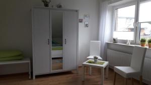 a room with a cabinet and a table and a window at Haus Hansen in Osterrönfeld