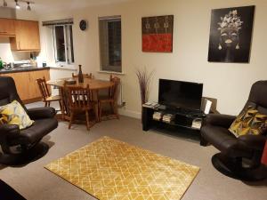 a living room with chairs and a table with a television at global relocation 2 Bed Apt Near Hatfield Station Free Parking in Hatfield