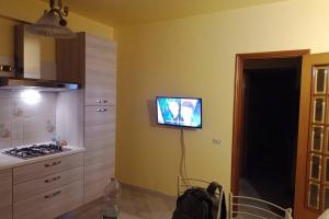 a kitchen with a tv hanging on the wall at Casa Helios in Lentini