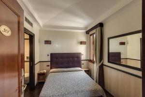 Een bed of bedden in een kamer bij Hotel Borromeo