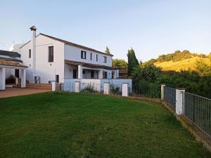 una casa blanca con una valla y un patio en Casa Rural El Chorrillo Cazalla de la Sierra, en Cazalla de la Sierra