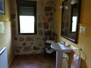 a bathroom with a sink and a mirror at Viv. De Uso Turístico Fuente el Tejo - Casa Ana in Burgohondo