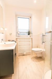 een badkamer met een wastafel, een toilet en een raam bij W3 - Gästehaus Christian-Westphal-Str 60 - FERIENDOMIZIL HOLLICH in Grömitz