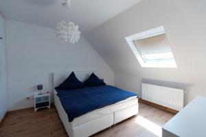 a bedroom with a bed with blue sheets and a skylight at Alte Schule Spittelstein 1OG rechts - a22965 in Rödental
